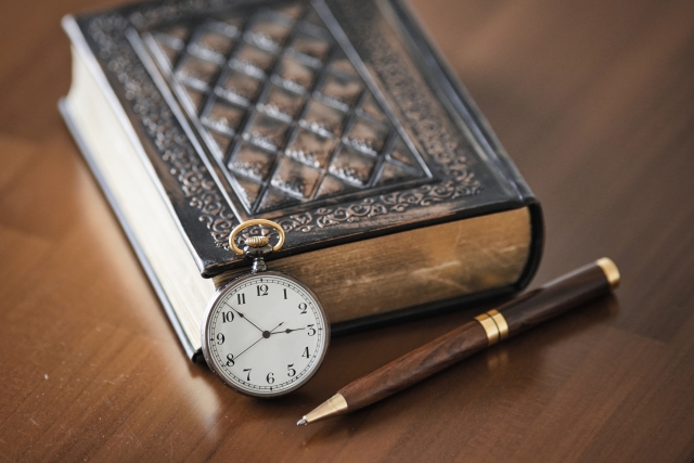 古いノートと時計とペン