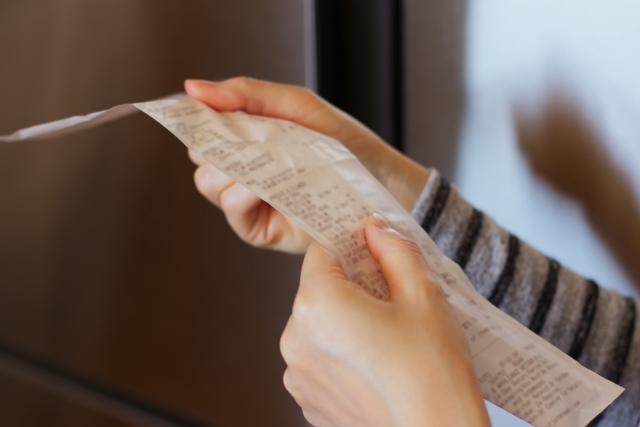 自宅でレシートを見る女性