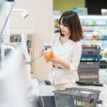 セルフレジで人参をスキャンする女性