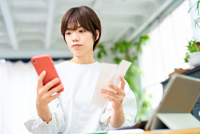 自宅でレシートを確認する女性