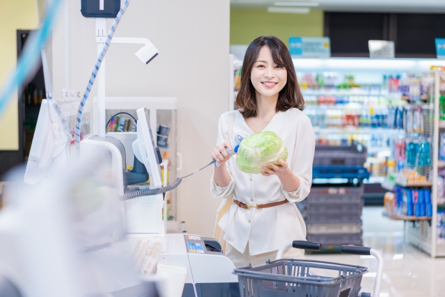 セルフレジで商品をスキャンする女性