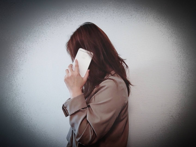 悪い知らせを電話で受ける女性