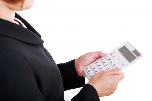 電卓を持つ喪服の女性