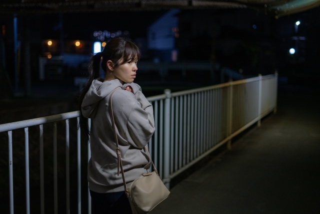 夜道で怯えて振り返る女性