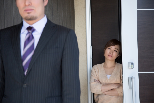 玄関で夫を送り出す妻