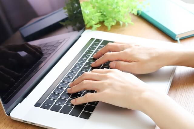 ノートパソコンを操作する女性の手元