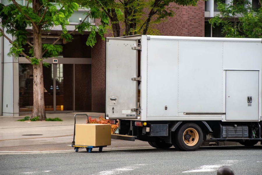 集合住宅のエントランス前に駐車した宅配便のトラック
